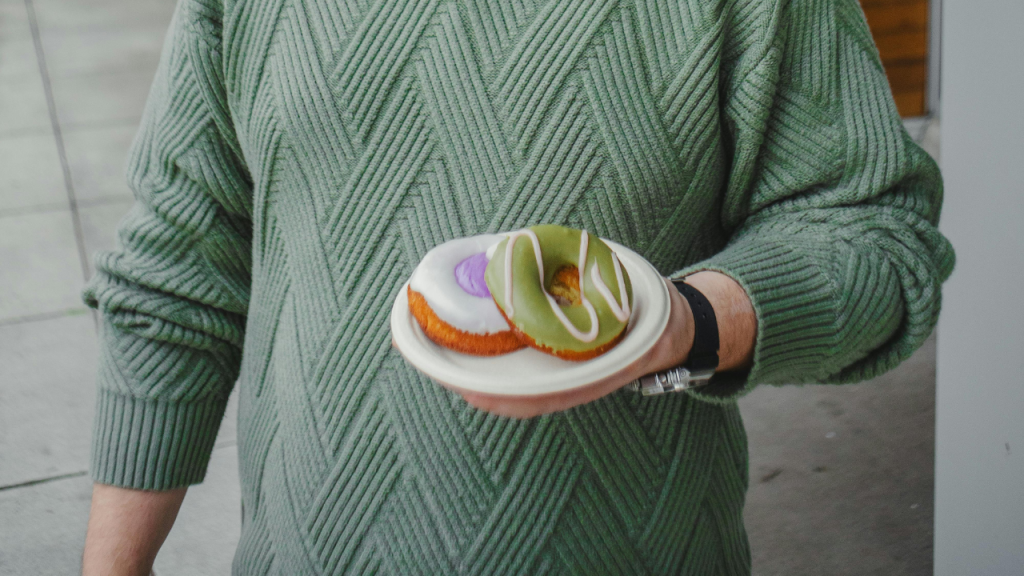 Person holding a plate of donuts.