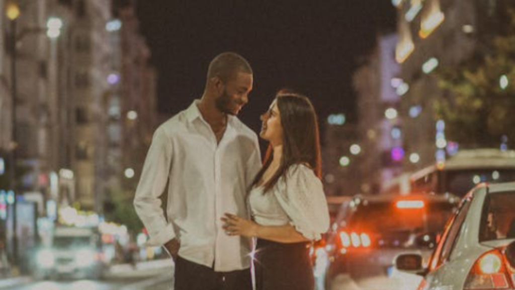 Romantic night street photo of a smiling couple embracing.