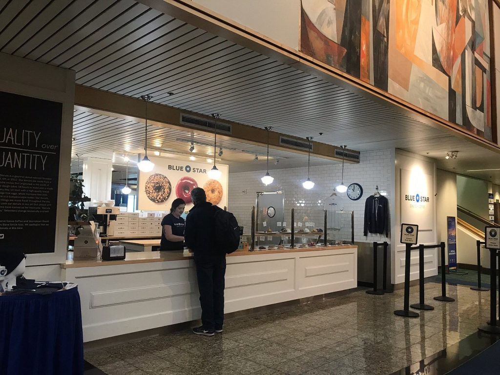Customer ordering donuts at the counter in Blue Star Donuts